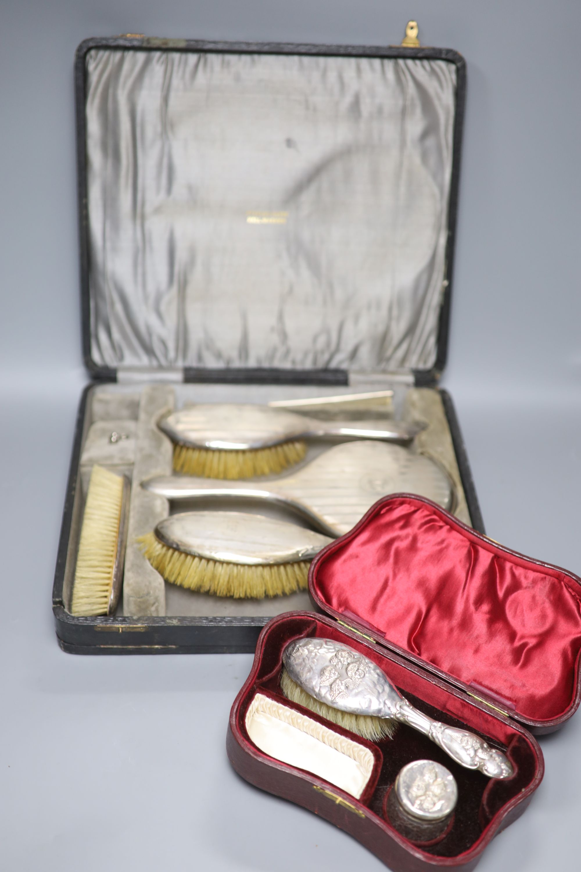Two cased silver dressing table sets